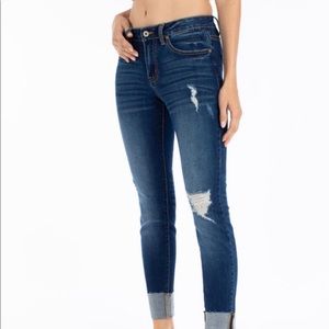 Dark jean with distressed detail and cuff hem